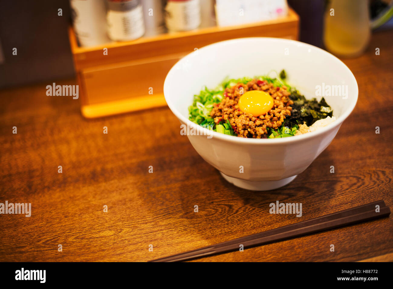 Un ramen noodle shop. Un bianco ciotola di Tagliatelle con verdure e un uovo. Foto Stock