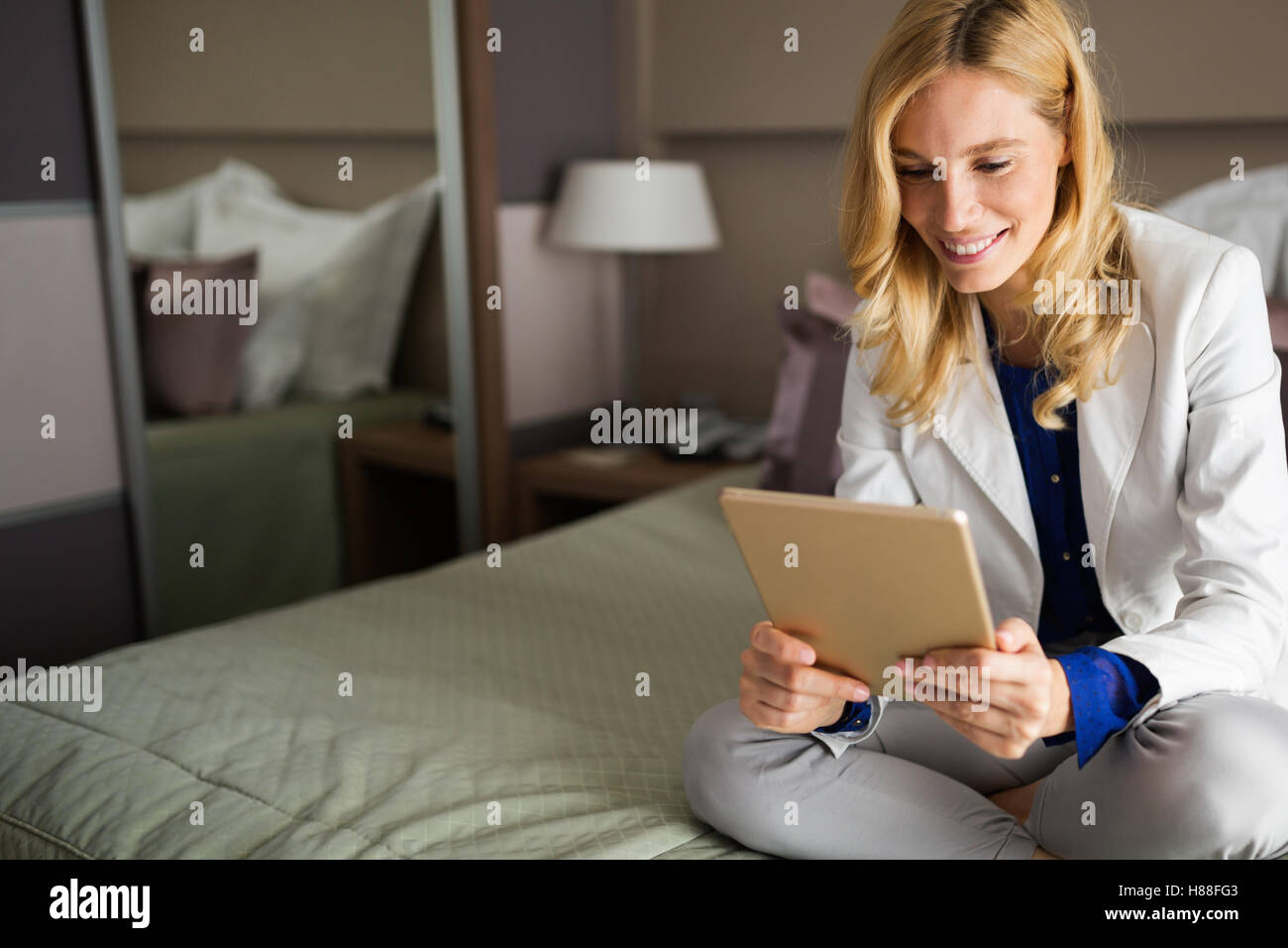 Imprenditrice in viaggio d'affari utilizzando tablet in camera da letto Foto Stock