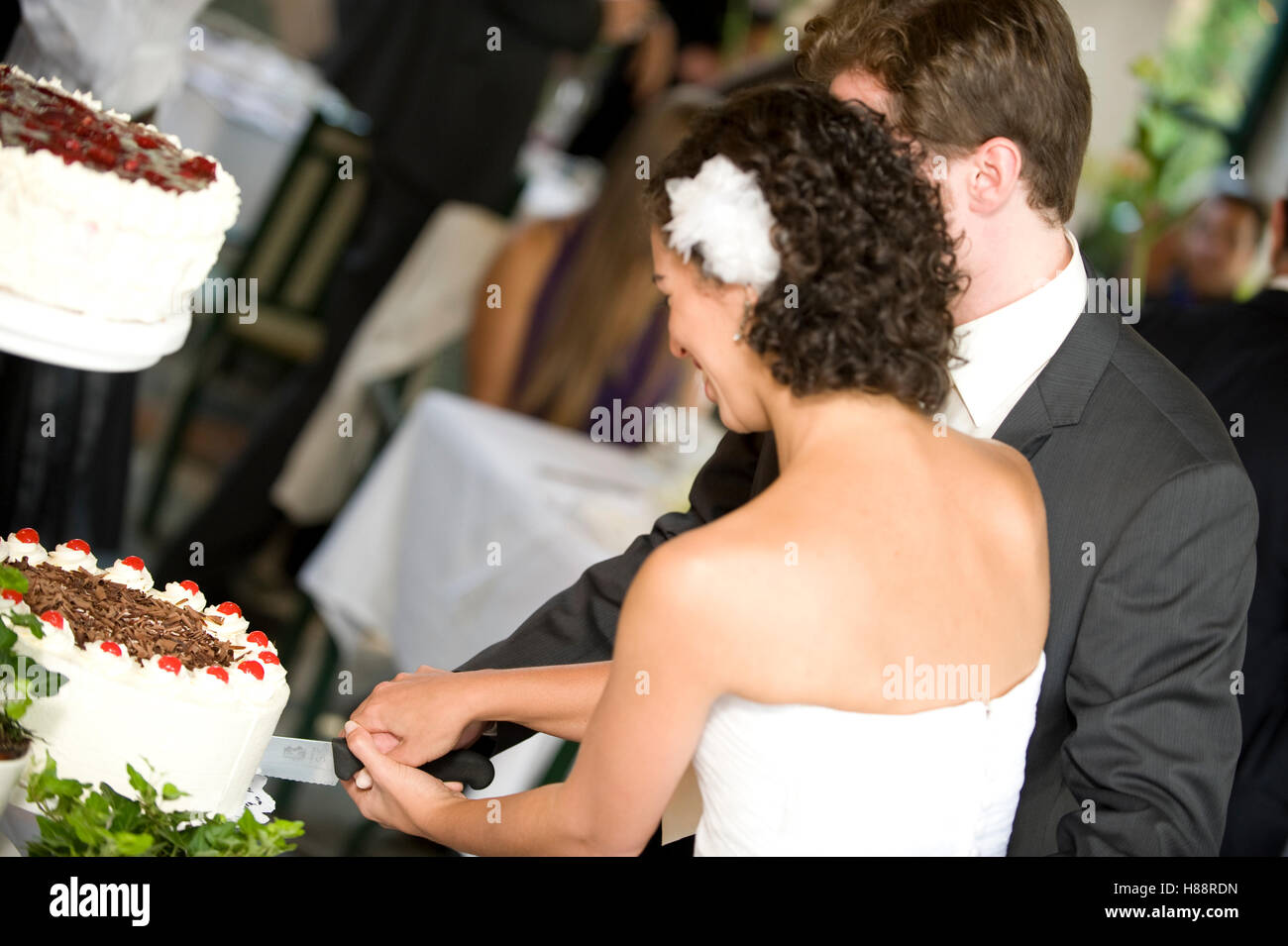Coppie in viaggio di nozze il loro taglio torta nuziale Foto Stock