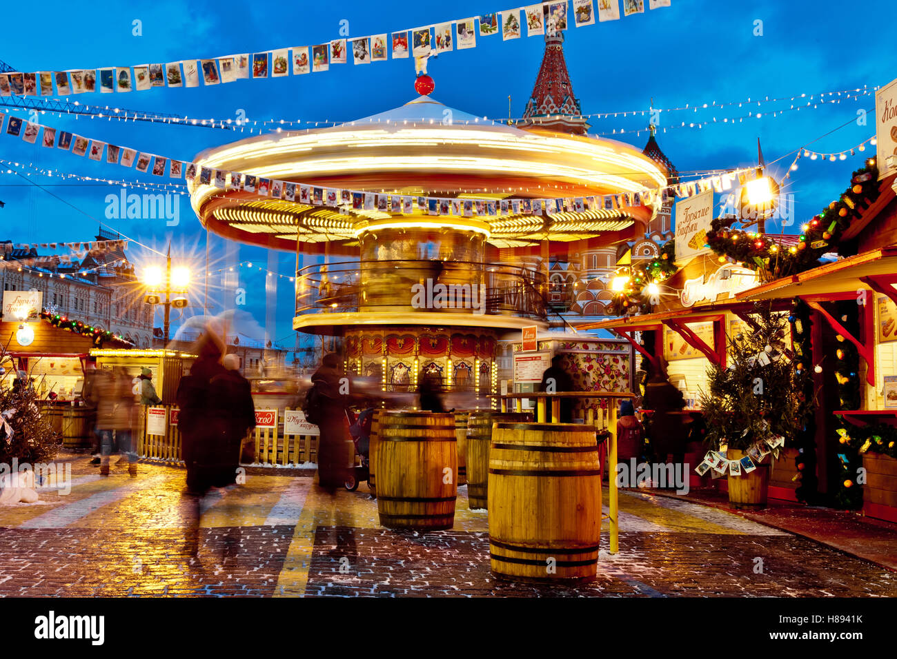 Le persone sul mercato di Natale sulla piazza Rossa di Mosca centro città, arredato ed illuminato quadrato rosso per Natale a Mosca. Giostra oscilla su bazaar di Natale Foto Stock