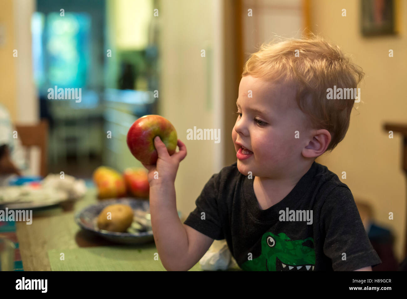 Detroit, Michigan - due-anno-vecchio Adamo Hjermstad Jr. si prepara a lanciare un apple attraverso il tavolo per la cena. Foto Stock