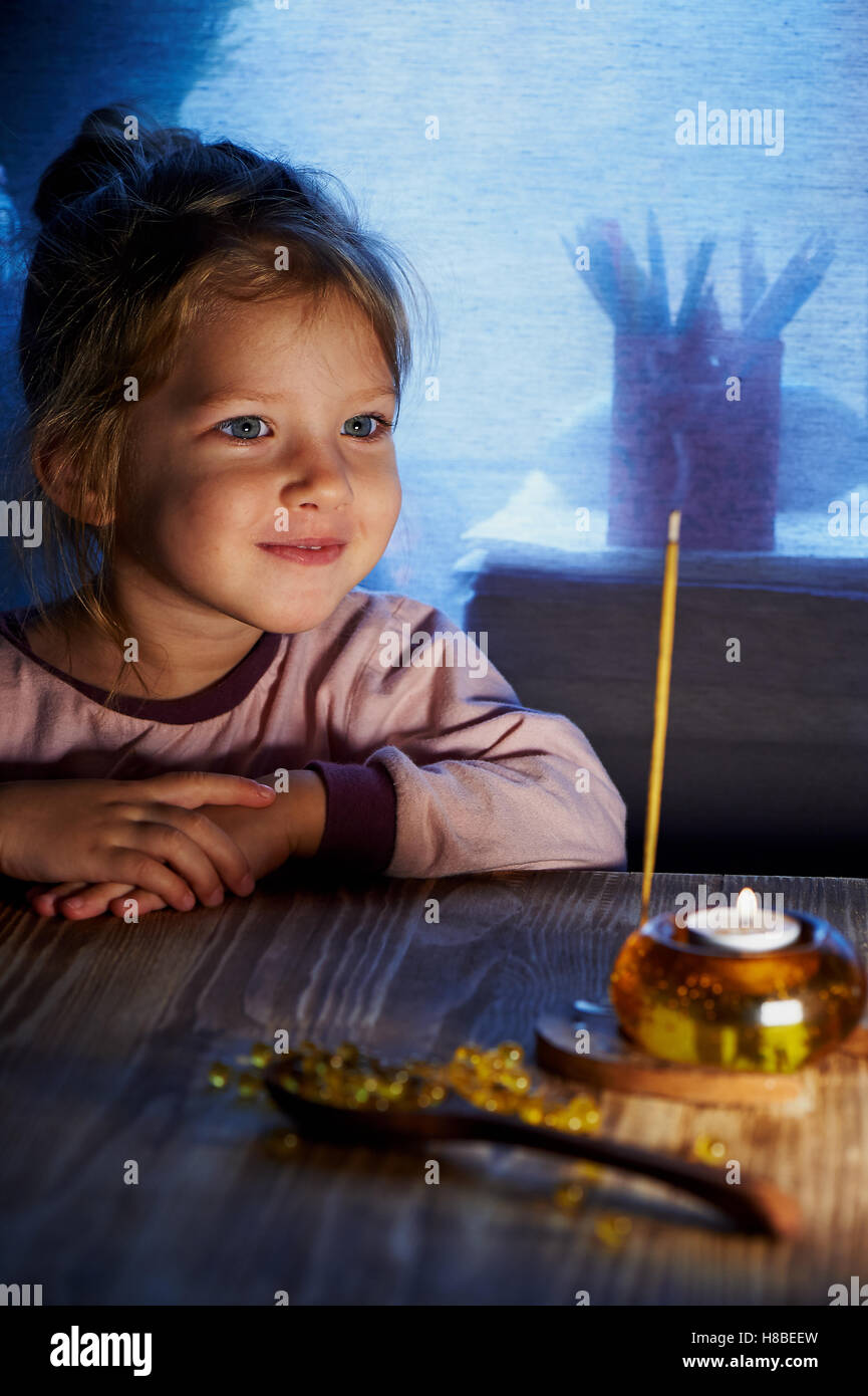 Bambina di 3 bambini guardando qualcosa come candela accesa nel candelabro.  Home calore e comfort come bambino Foto stock - Alamy