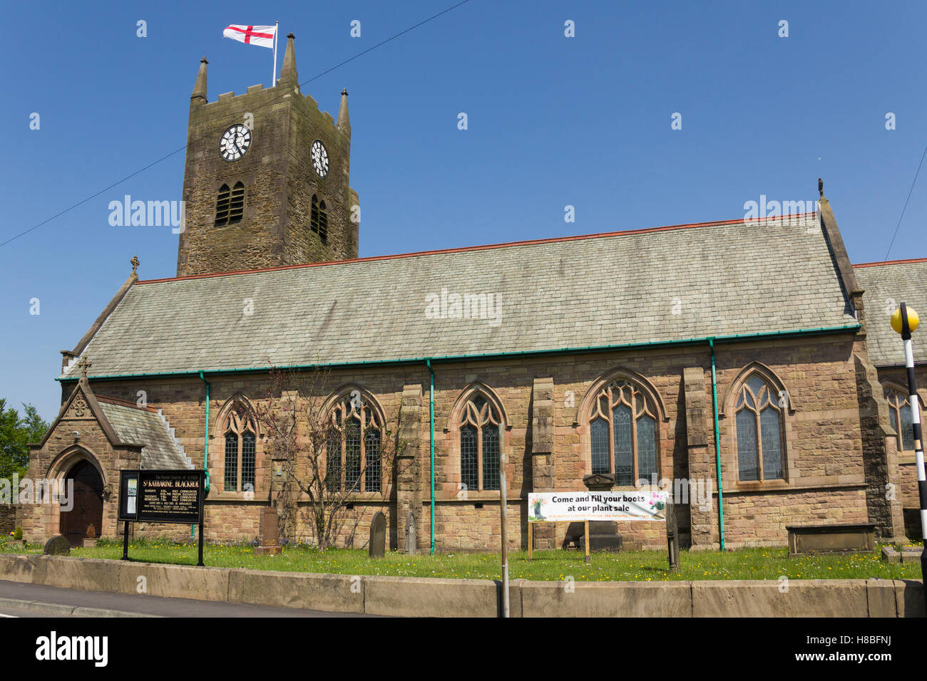 San Katharine chiesa, Blackrod vicino a Bolton, Lancashire con un banner pubblicitari la prossima vendita di piante. Nota il meno com Foto Stock