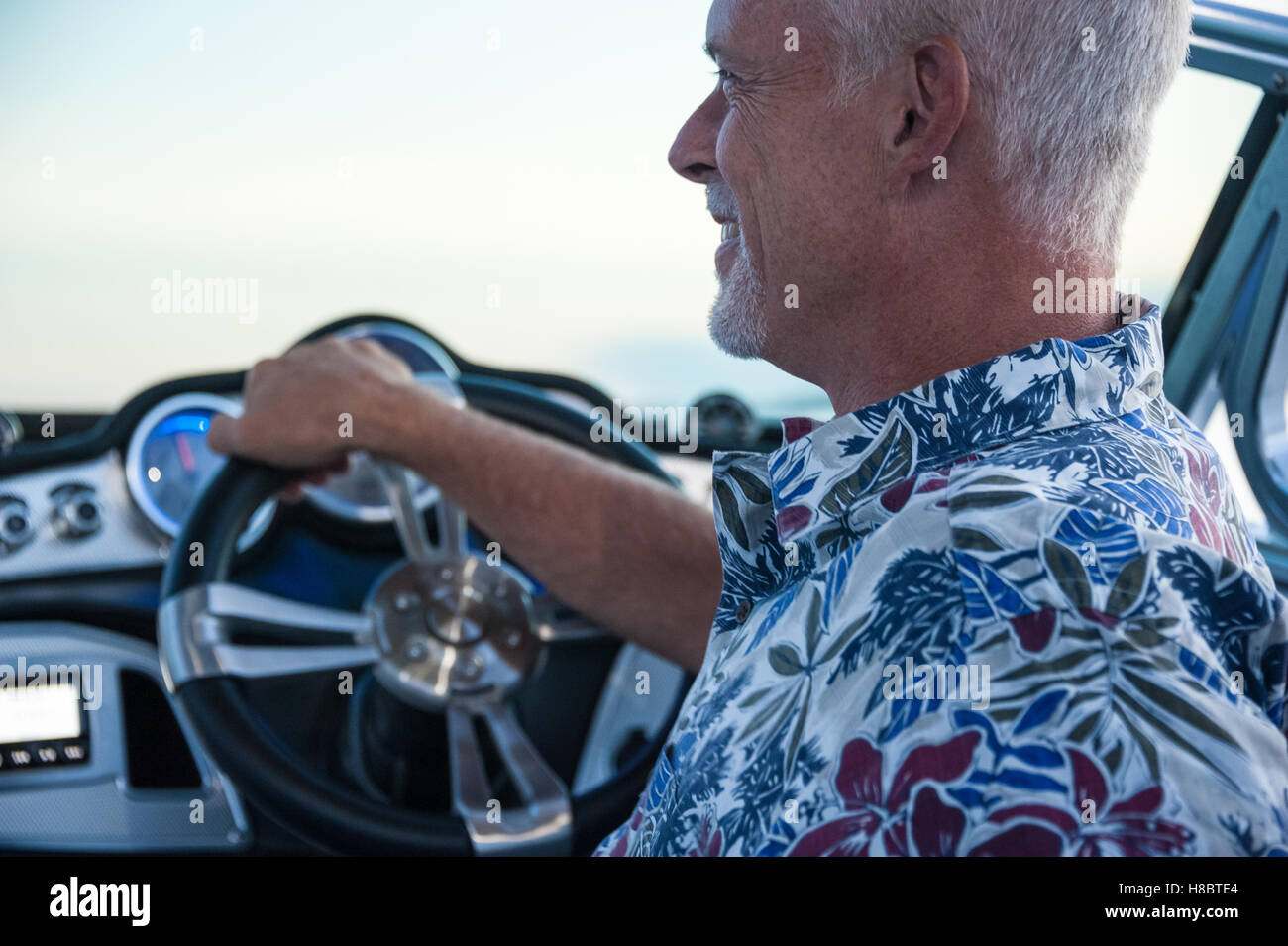 Senior uomo godendo di una serata sul lago nella sua scia Mastercraft navigando in barca. Foto Stock