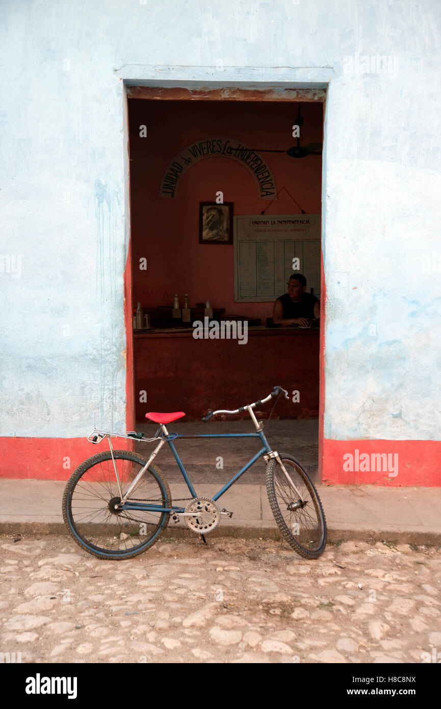 Una vecchia bicicletta si appoggia contro il marciapiede in una strada a ciottoli in Trinidad, Cuba Foto Stock