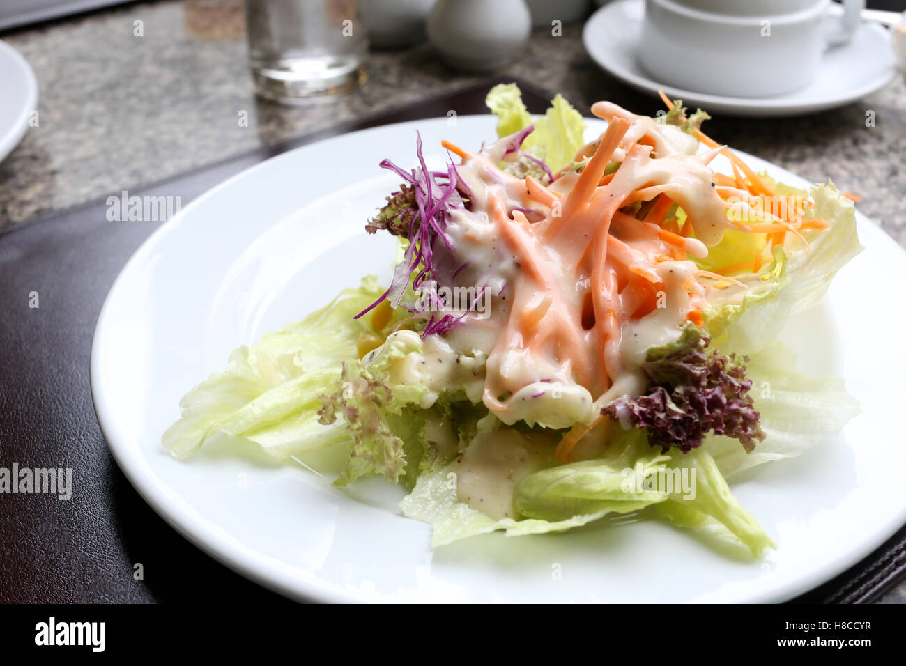 Verdure miste per insalata sul piatto bianco nel ristorante. Foto Stock
