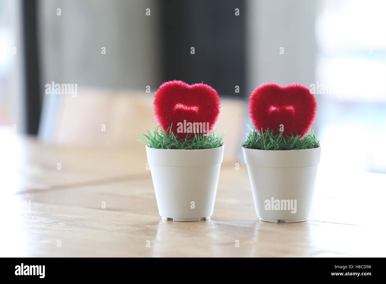 Vaso con cuore artificiale posto sulla tavola in concetto di matrimonio e l'amore. Foto Stock