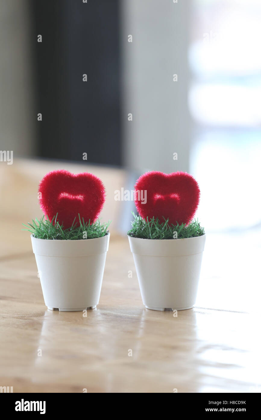 Vaso con cuore artificiale posto sulla tavola in concetto di matrimonio e l'amore. Foto Stock