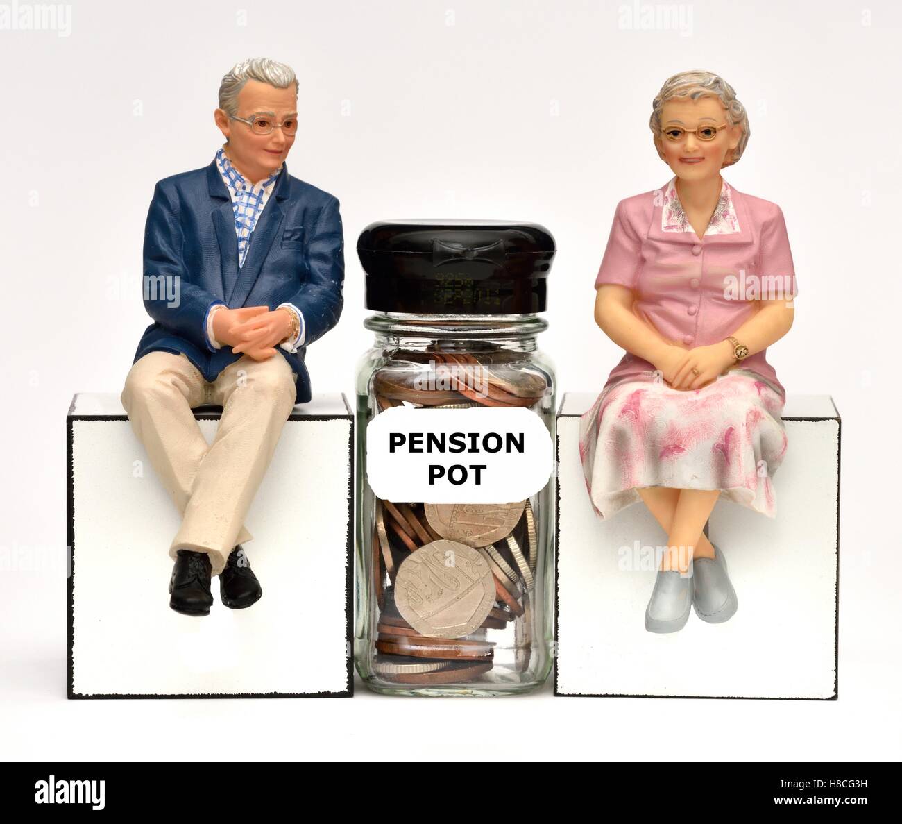Due figurine di pensionati con una pensione pot vaso di denaro. Foto Stock