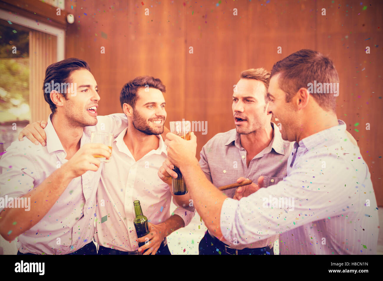 Immagine composita di un gruppo di giovani uomini avente le bevande Foto Stock