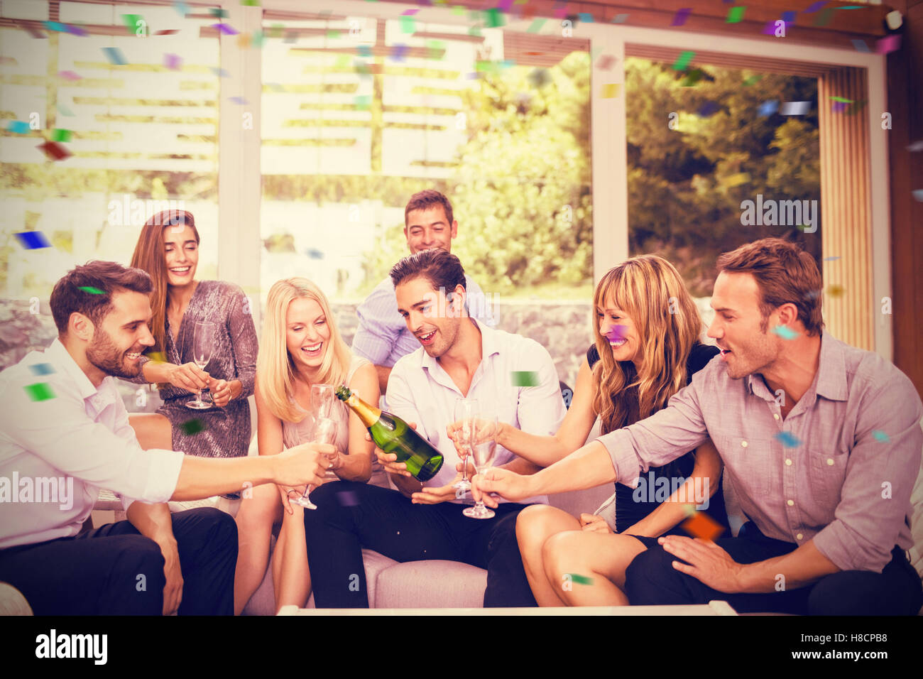 Immagine composita dell'uomo versando champagne per gli amici Foto Stock