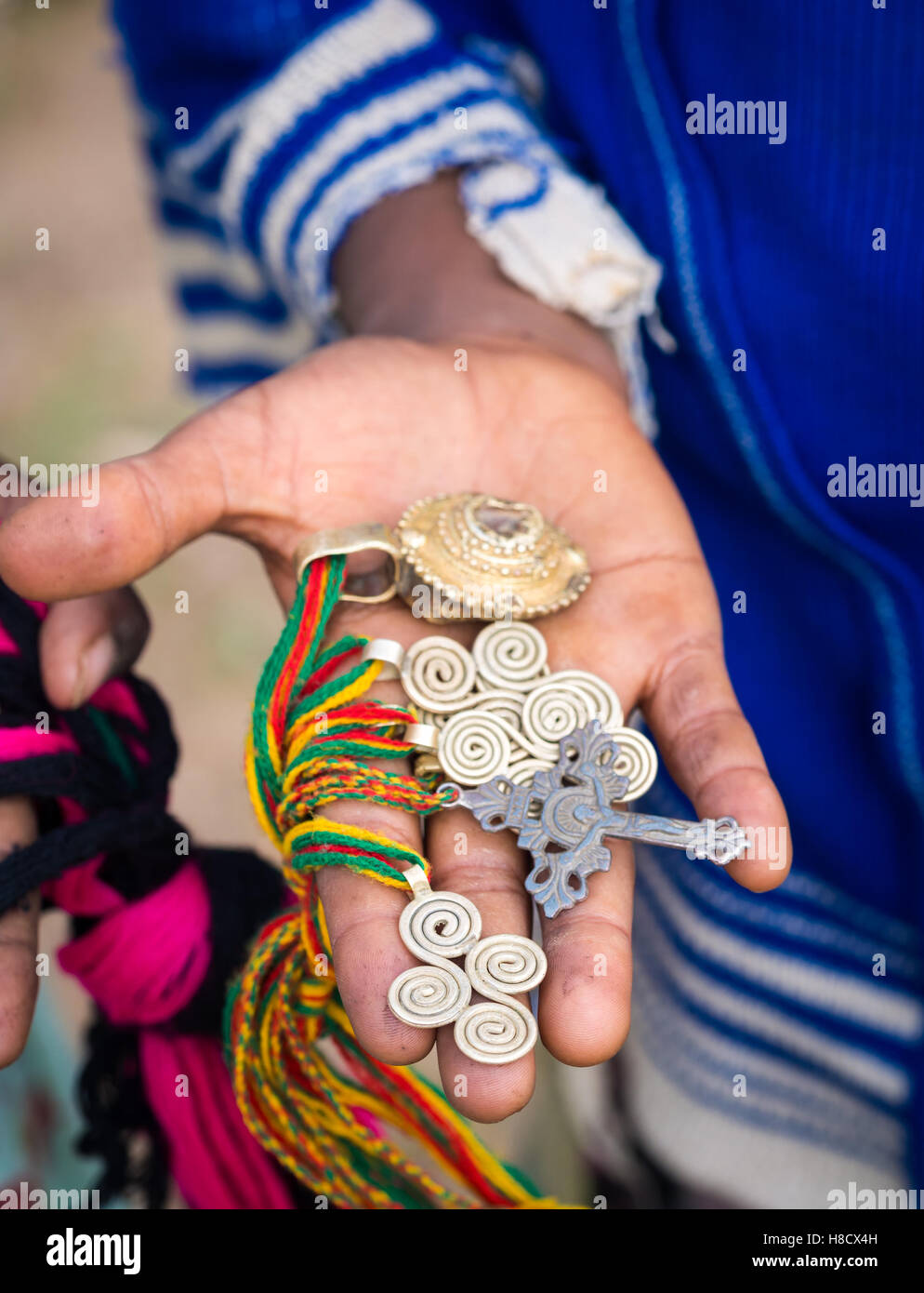 Croci e altri simboli venduti come souvenir da ragazzi locali vicino ad Axum, Etiopia. Foto Stock