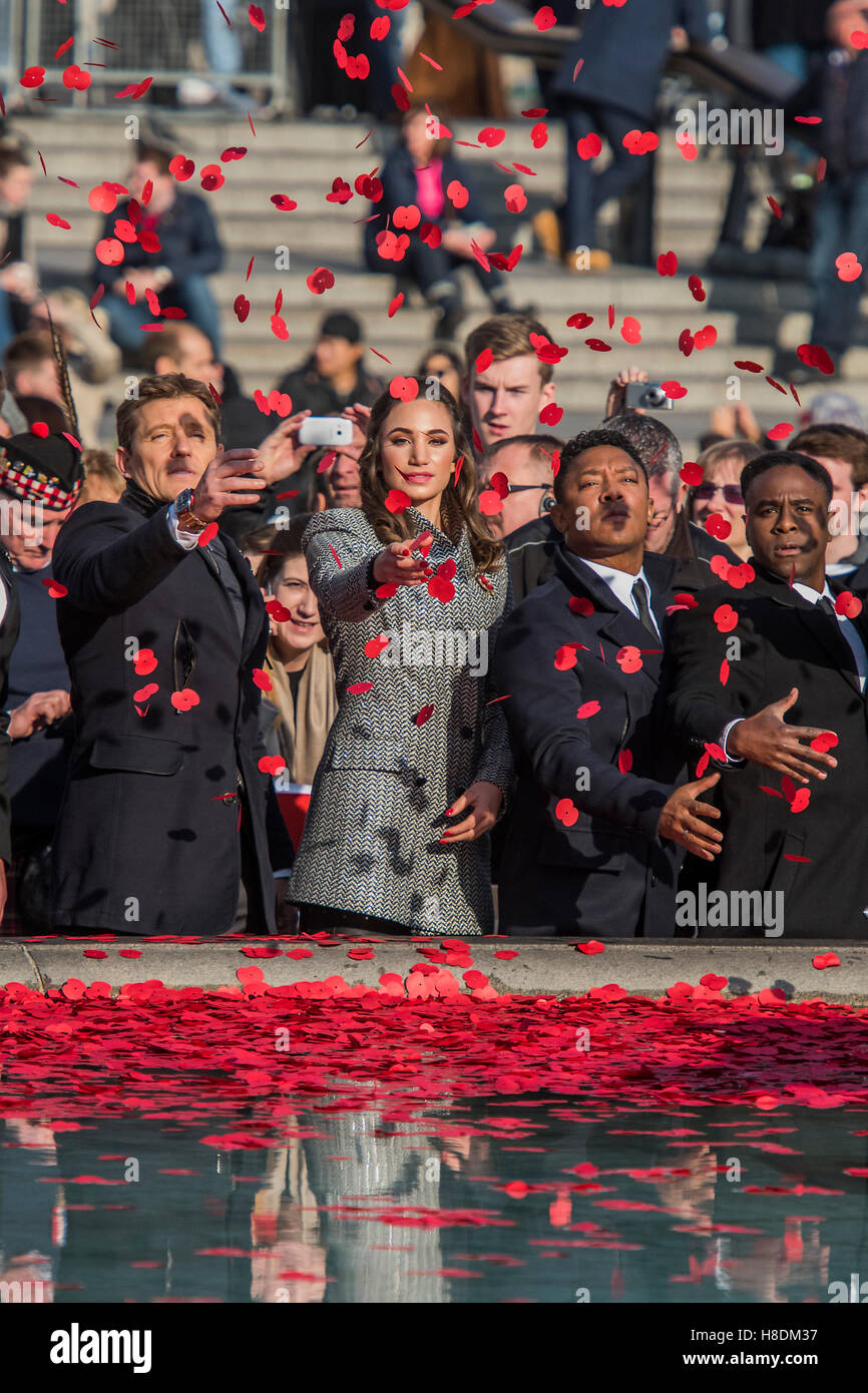 Londra, Regno Unito. 11 Novembre, 2016. Laura Wright, uniti da Ben Pastore (L) e membri di Vox Fortura (R), getta il papavero nella fontana - il silenzio in piazza oraganised dalla British Legion in Trafalgar Square - 11 novembre 2016, Londra. Credito: Guy Bell/Alamy Live News Foto Stock