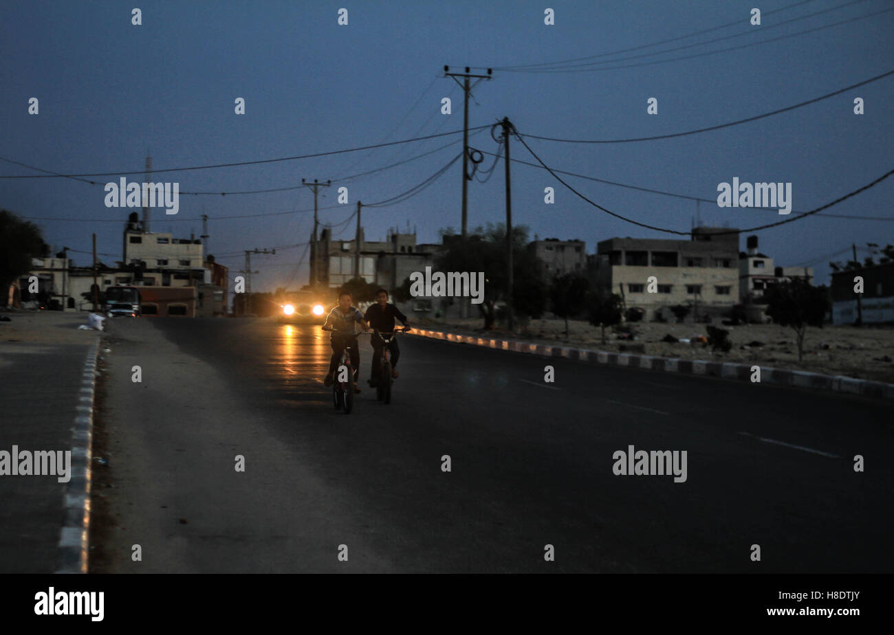 Khan Yunis, Striscia di Gaza, Territorio palestinese occupato. Xi Nov, 2016. Bambini palestinesi stanno portando in bici a piedi in una delle strade nel sud della striscia di Gaza, una fuga dalle case ovunque una uscita per loro, sotto costante crisi blackout nove anni fa. Credito: Ahmad Salem/ZUMA filo/Alamy Live News Foto Stock