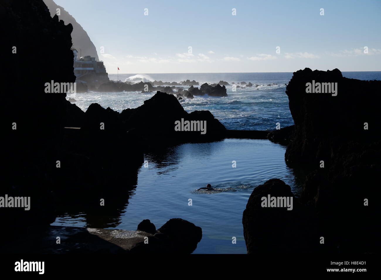Nuotatore nuoto nelle piscine naturali di origine vulcanica in Porto Moniz, Madeira, Portogallo Foto Stock