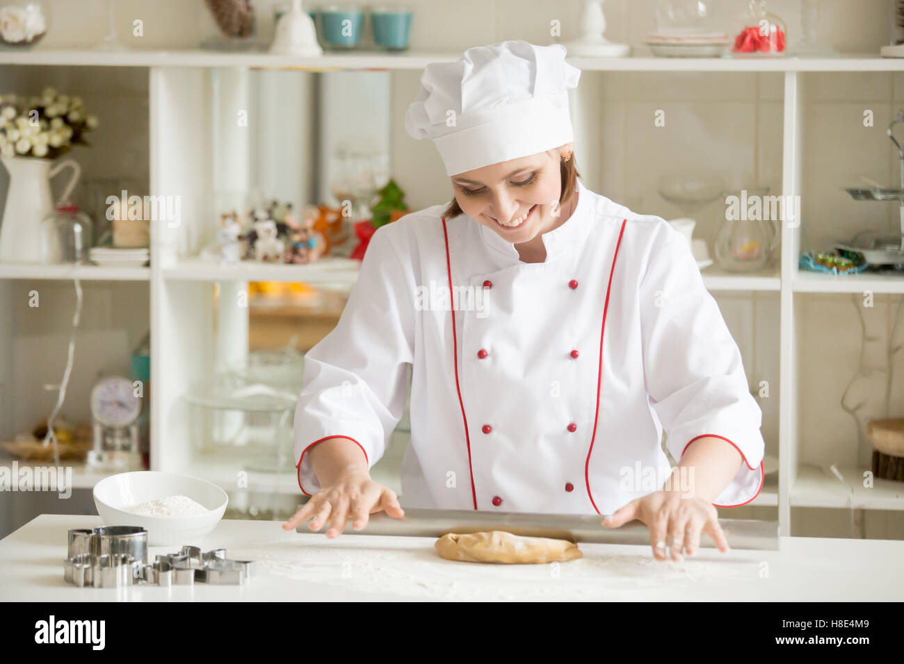 Sorridente pasticcere professionale rolling gingerbread impasto Foto Stock