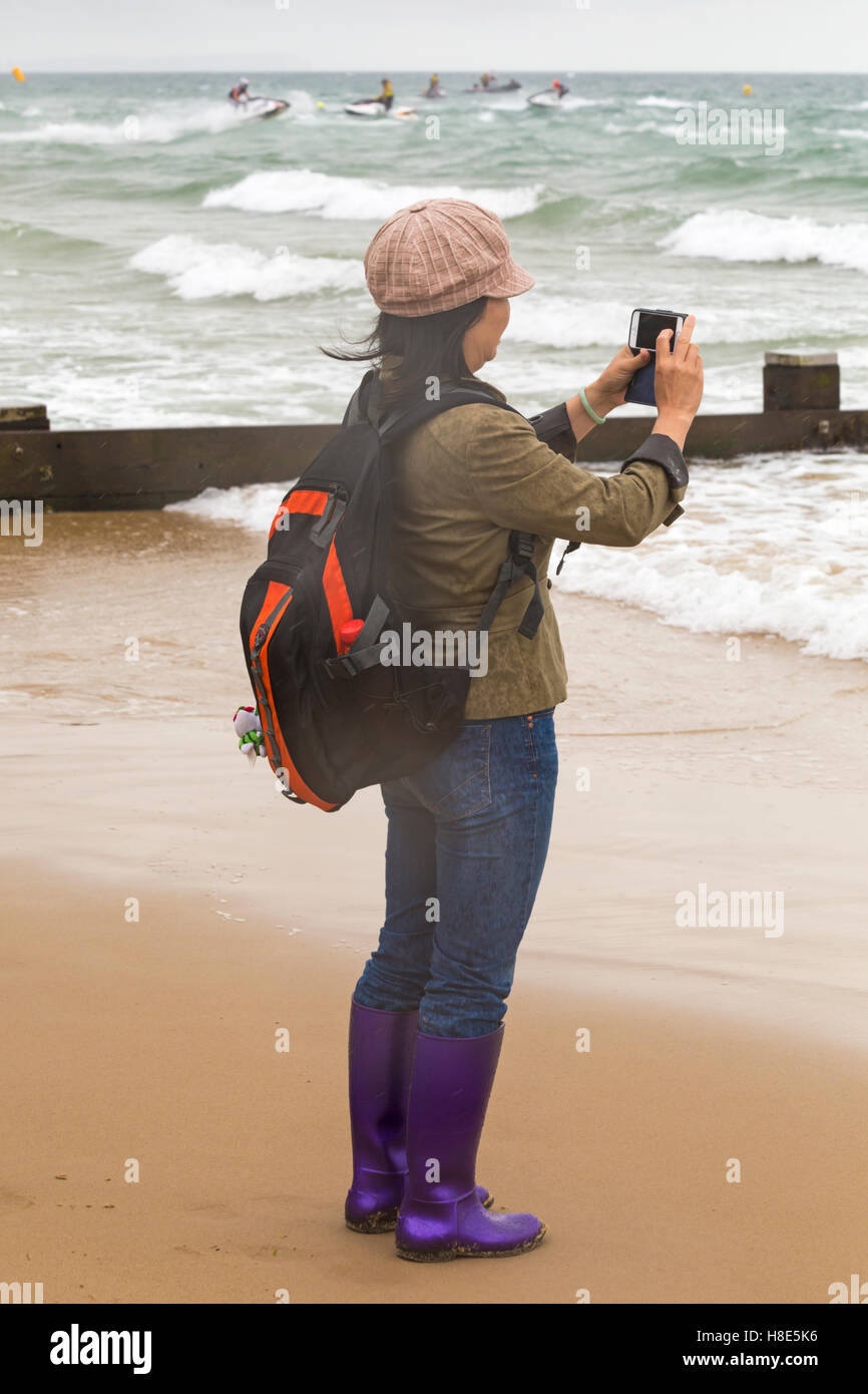 Donna prendendo foto sul telefono di Aqua X Campionati Jetski jet ski racing al Grand Prix del mare a Bournemouth in Settembre Foto Stock