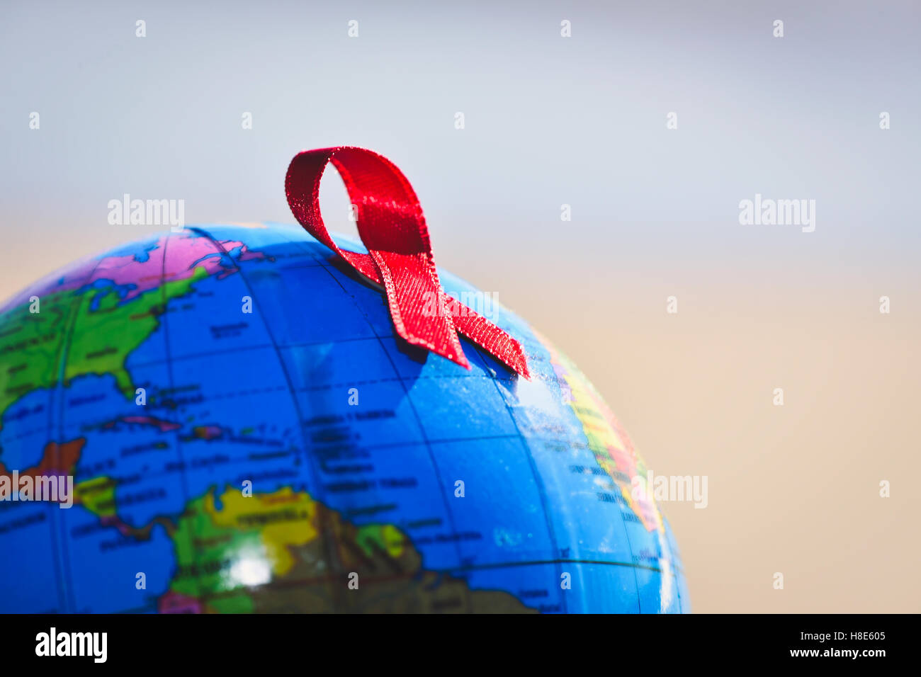 Primo piano di un mondo globale con un nastro rosso per la lotta contro l AIDS Foto Stock
