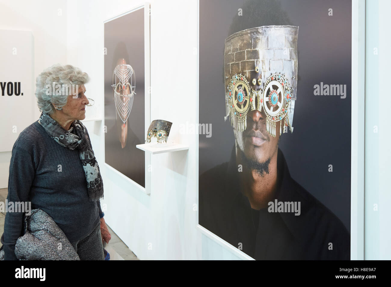 Donna che guarda la foto di uomo con maschera durante Artissima, fiera di arte contemporanea apertura Foto Stock