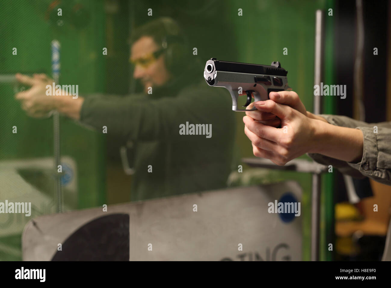 Imparare a sparare una pistola. Auto-difesa, la donna presso il poligono di tiro Foto Stock