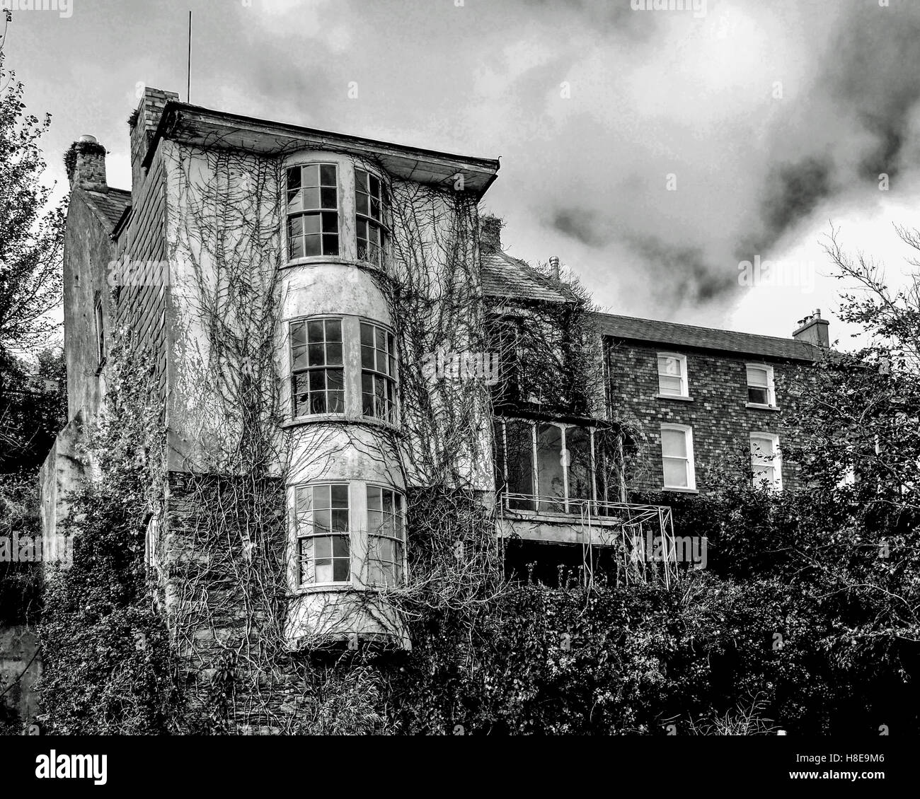 Spooky/scary cercando casa in Kinsale, County Cork, Irlanda sotto un cielo drammatico. Foto Stock