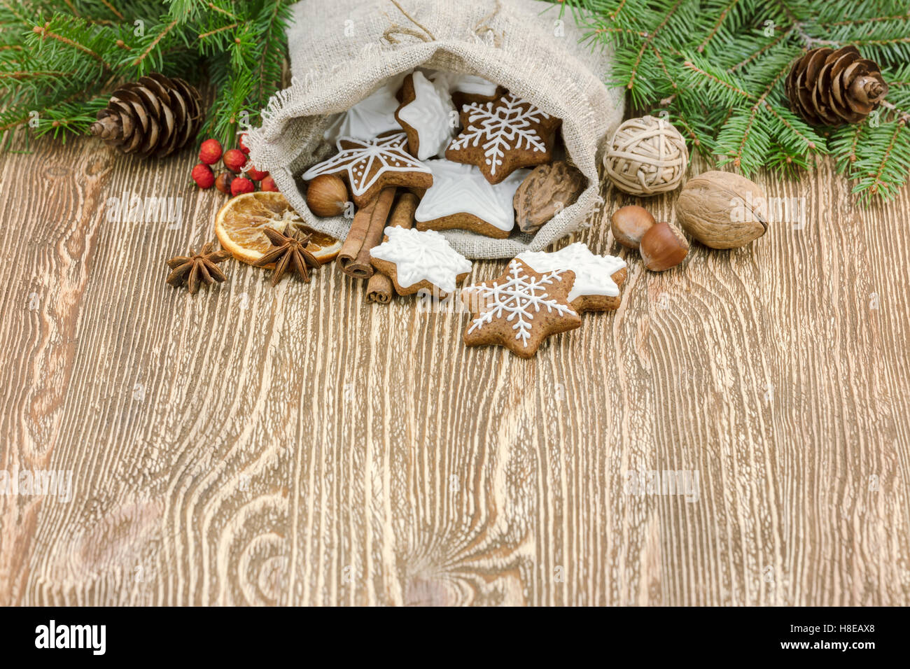 Natale in casa gingerbread cookies nella piccola borsa regalo su sfondo di legno di abete rami Foto Stock