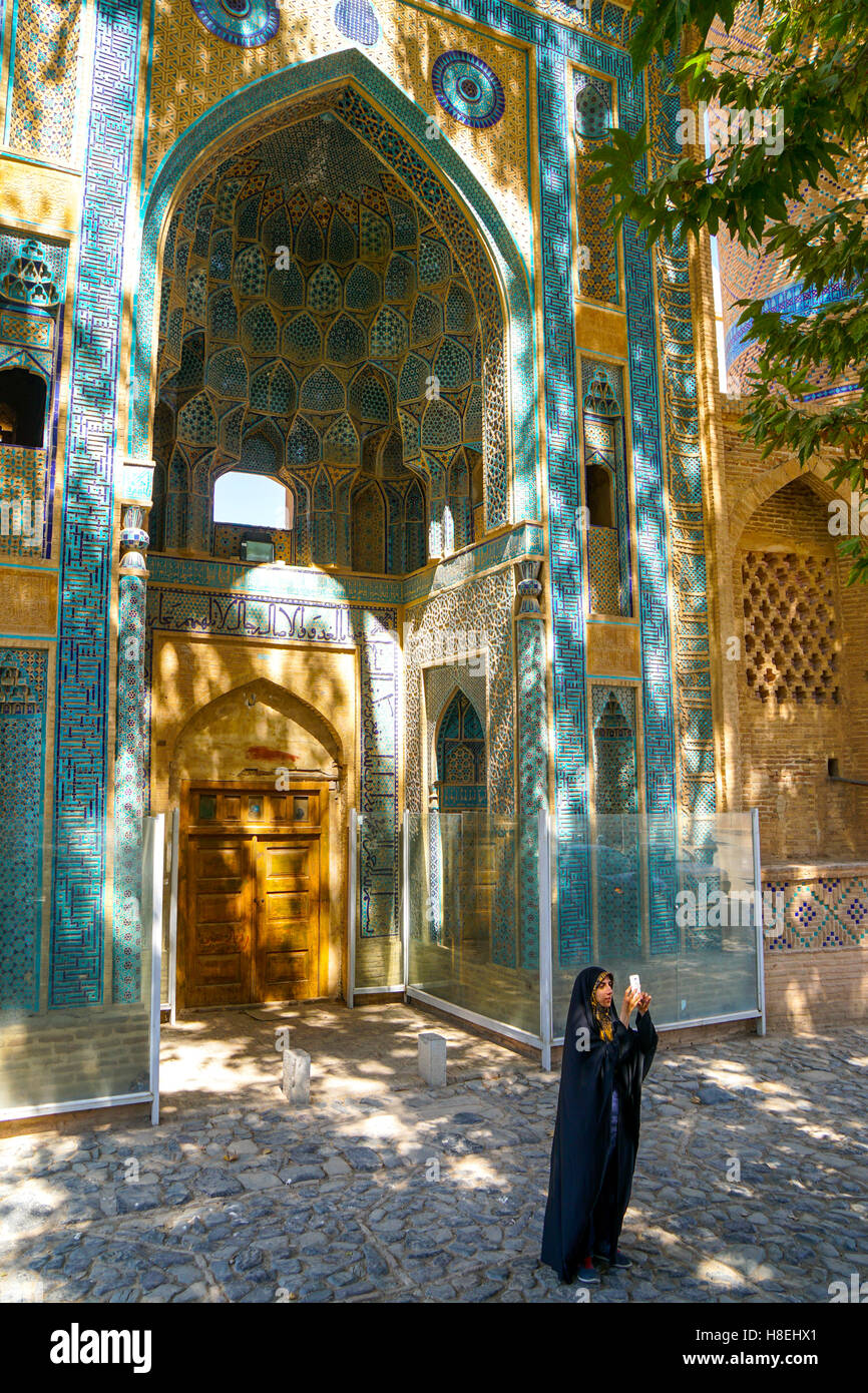 Giovane ragazza iraniana in chador prendendo foto nella parte anteriore della moschea Jameh, Natanz, Iran, Medio Oriente Foto Stock