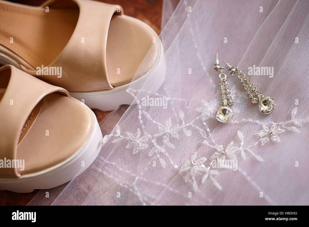 Brides scarpe e orecchini su un bianco velo di nozze Foto Stock