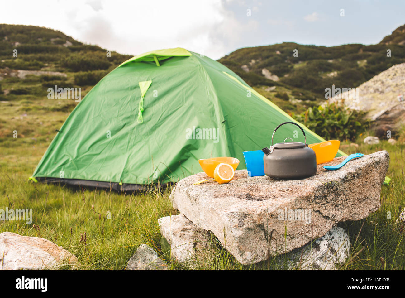 Camping teiera e il tappo sul prato all'orario di alba. Le montagne della Bulgaria. Foto Stock