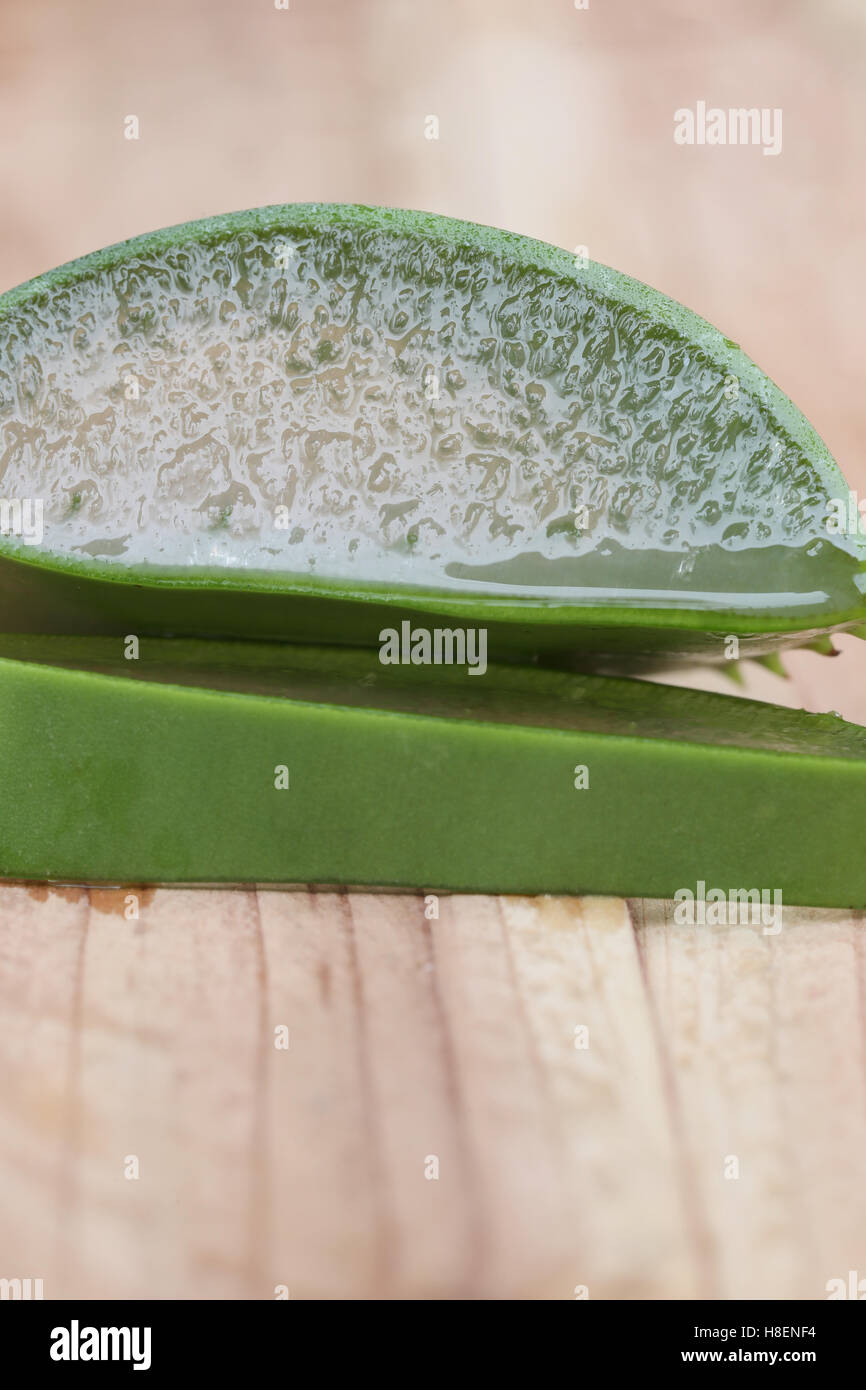 Aloe vera fetta su un pavimento in legno e si può vedere la texture di aloe vera gel. Foto Stock