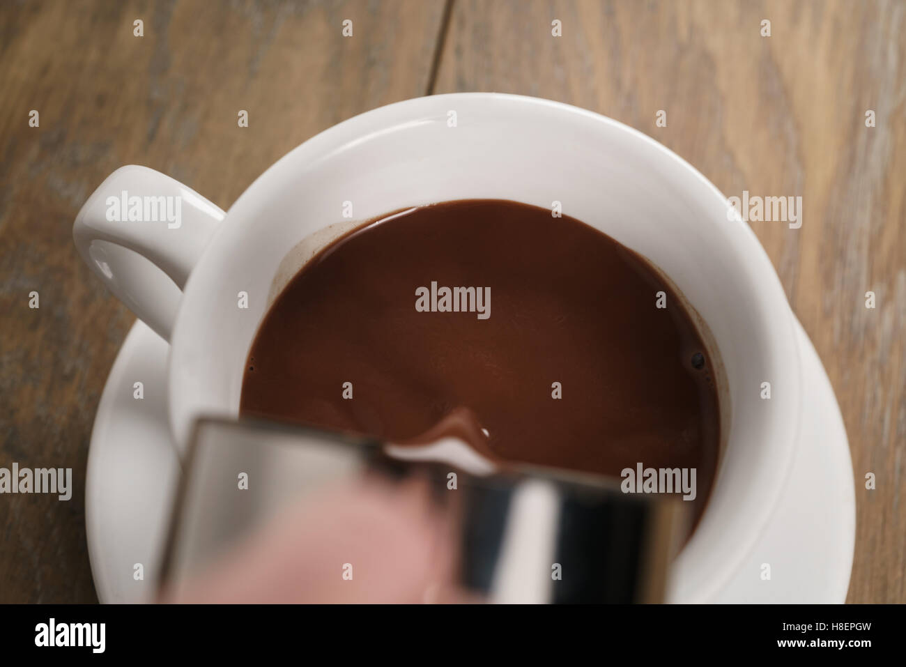 Cioccolata calda versando in coppa Foto Stock