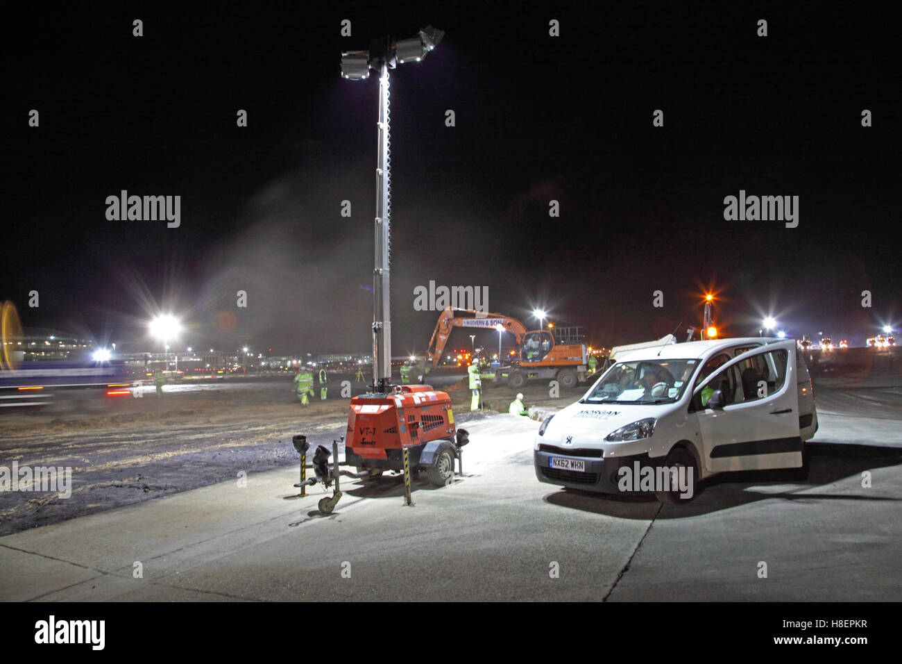 Un autonomo, mobile torre di illuminazione fornisce l'illuminazione per il pernottamento pista resurfacing presso l'aeroporto di Heathrow Foto Stock