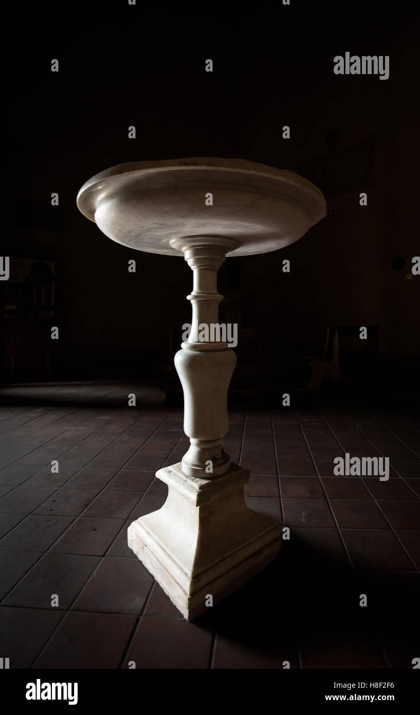 Chiesa di font con illuminazione soffusa. Foto Stock