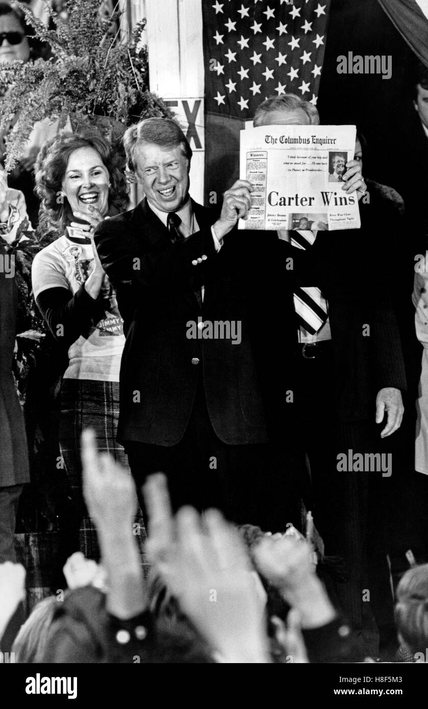 Eletto presidente Jimmy Carter tiene un giornale con il titolo 'Carter vince!" come egli celebra con la folla riempire le strade di minuscoli pianure, Georgia sull elezione notte nel 1976. Foto Stock