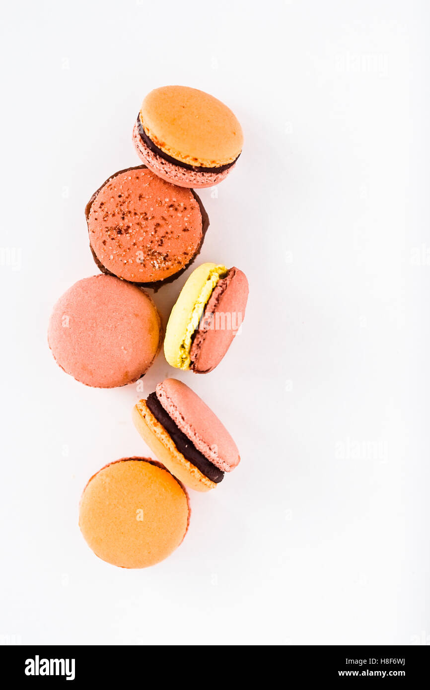 French macarons con glassa al cioccolato in rosa e arancio. Sfondo bianco. Vista superiore Foto Stock