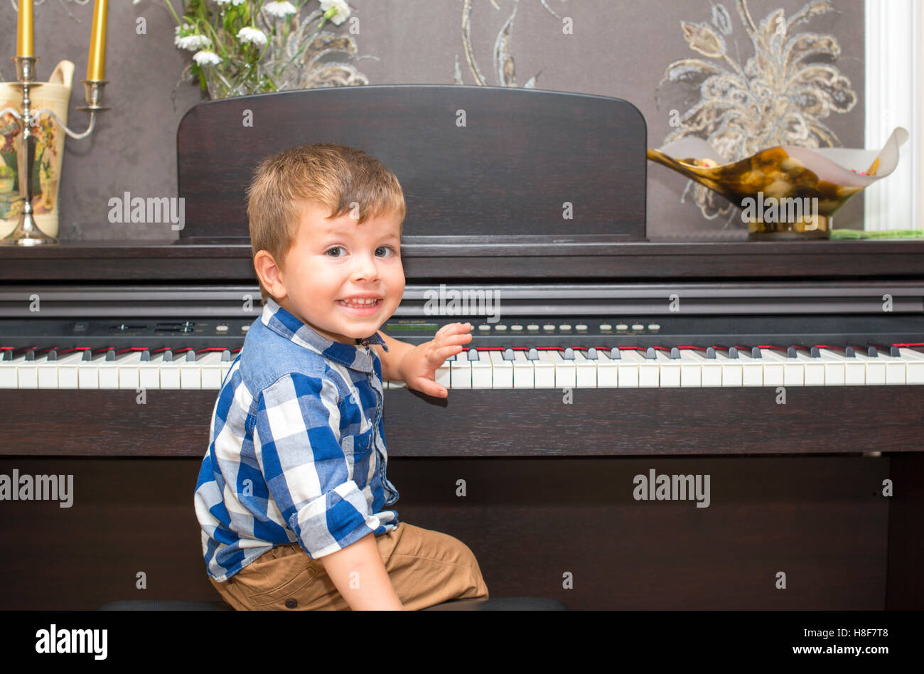 Felice ragazzo a suonare il pianoforte a casa Foto Stock