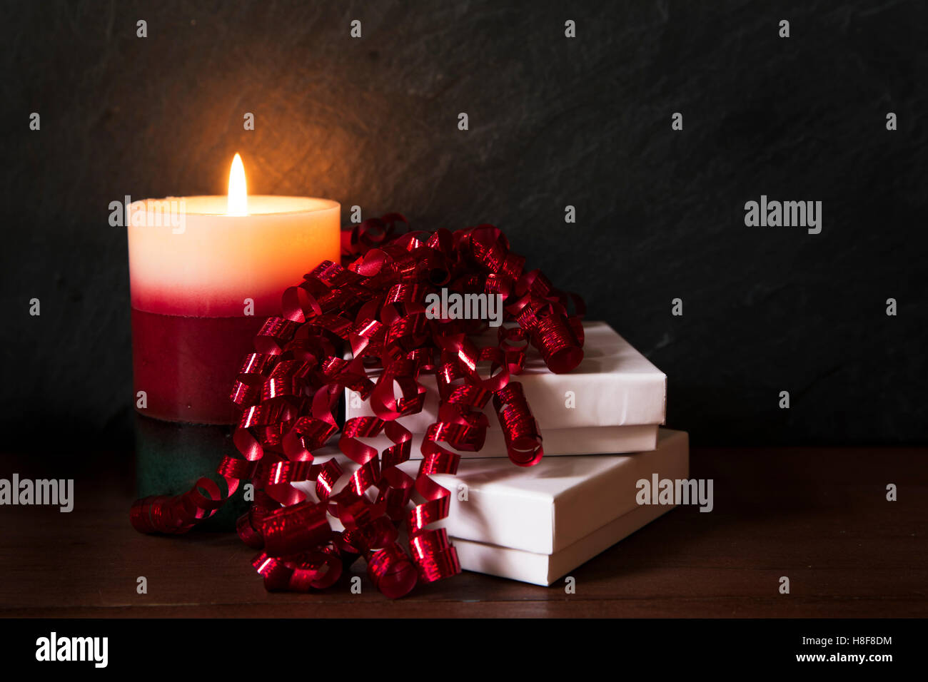 Due confezioni regalo con parentesi nastro rosso e la festa di candela. Foto Stock