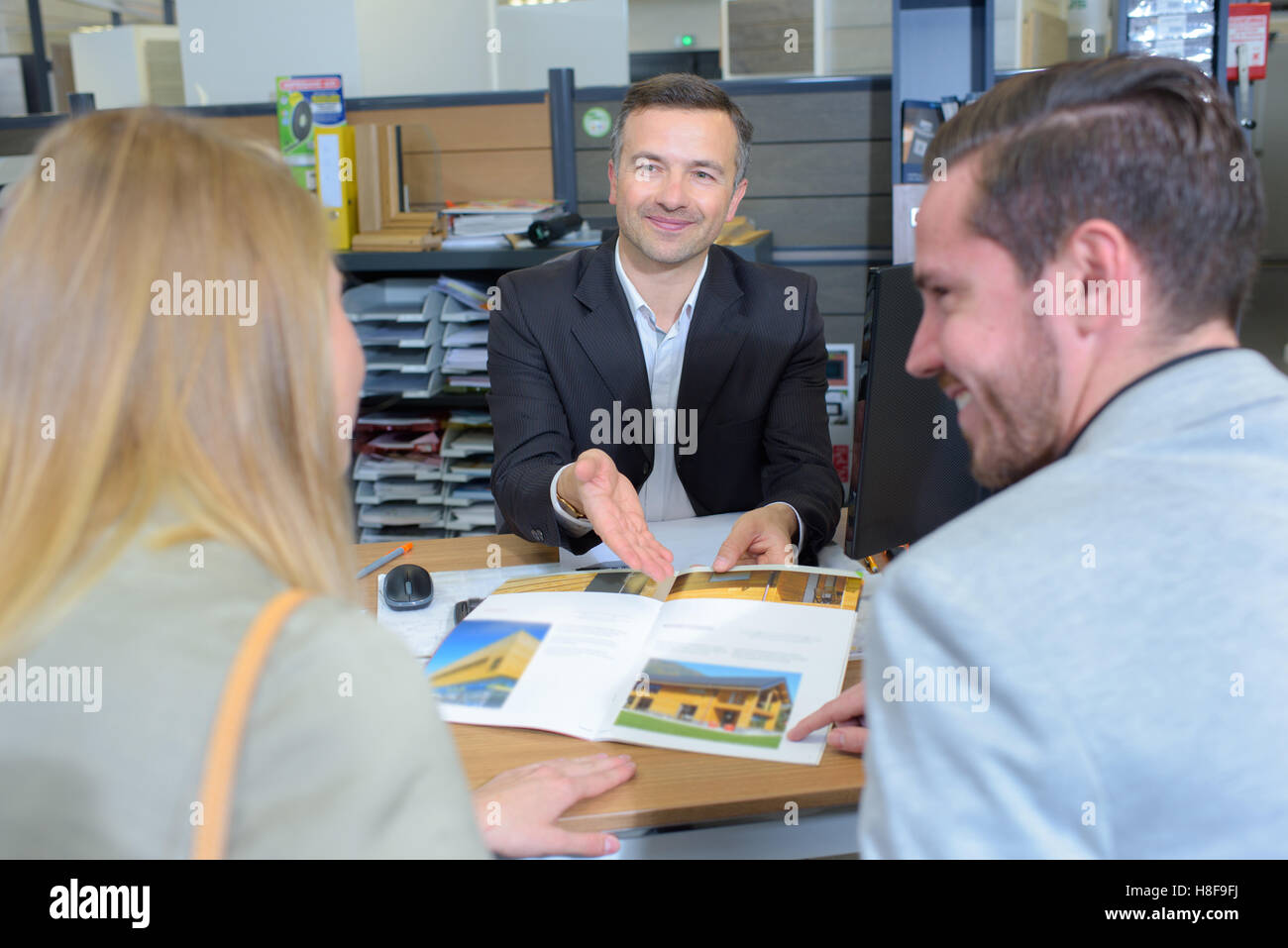 Venditore mostra brochure per paio Foto Stock