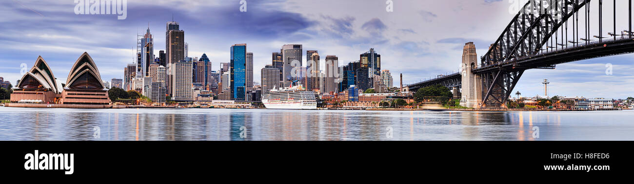 Sydney punti di riferimento della città vista panoramica attraverso il Sydney Harbour lungo il Ponte del Porto di arco verso cityscape grattacieli di sunrise Foto Stock