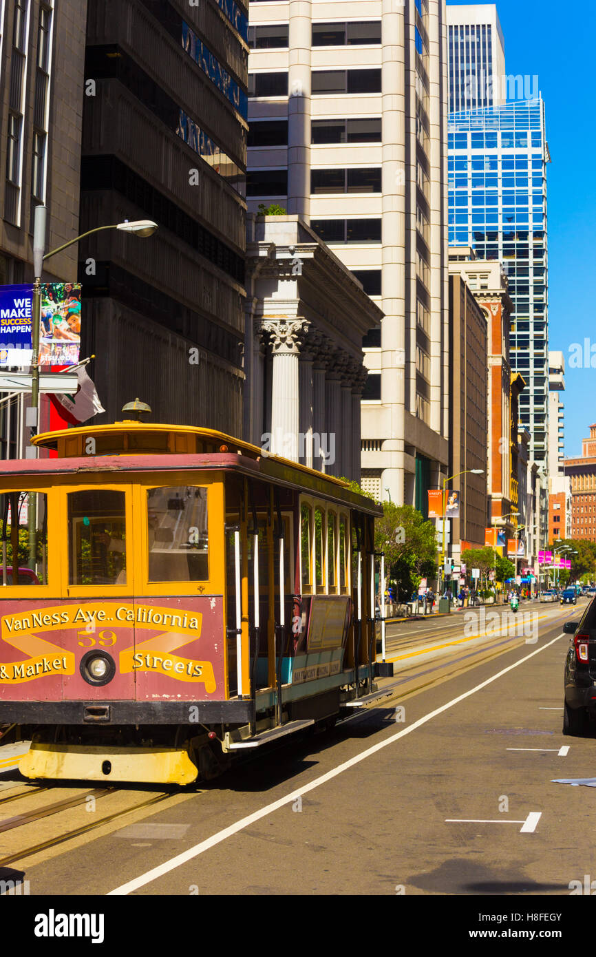 Iconico funivia rotolando giù California Street verso il mercato nel quartiere finanziario del centro cittadino tra edifici di uffici. In verticale Foto Stock