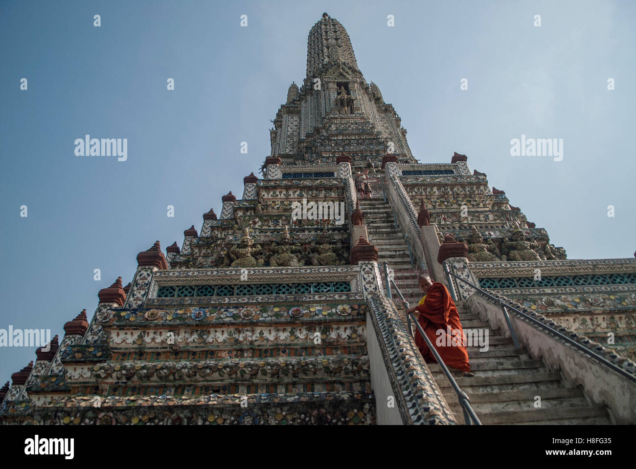 Un monaco buddista scendendo i passaggi sul tempio di Dawm Bangkok, Thailandia Foto Stock