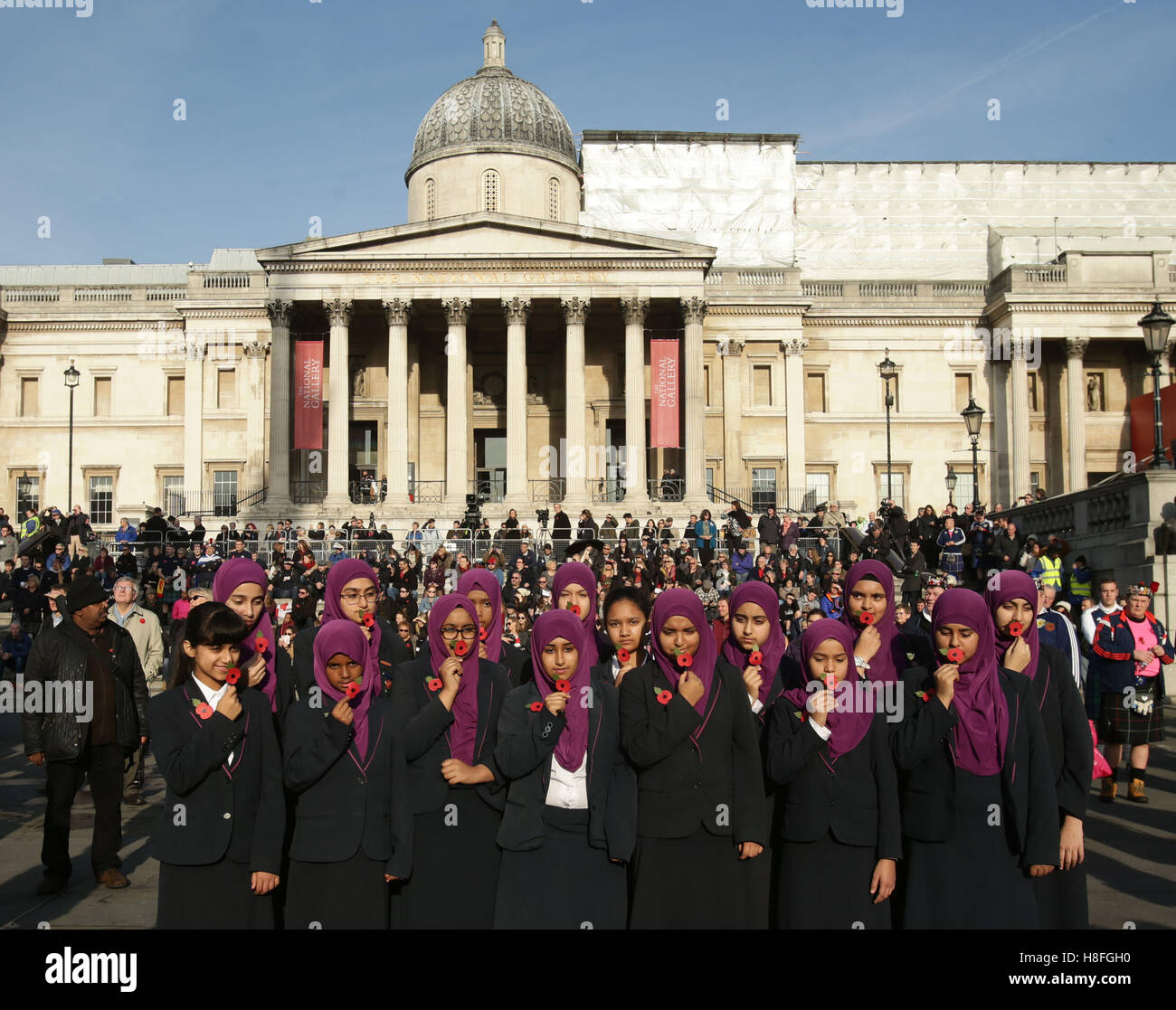 Due minuti di silenzio è osservata dalle ragazze durante un evento a Londra in Trafalgar Square per contrassegnare il giorno dell'armistizio. Foto Stock