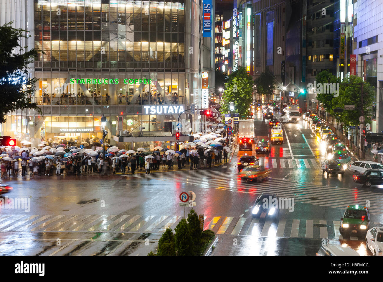Tokyo, Giappone. Il traffico che fluisce liberamente attraverso l'incrocio di Shibuya di notte. Foto Stock