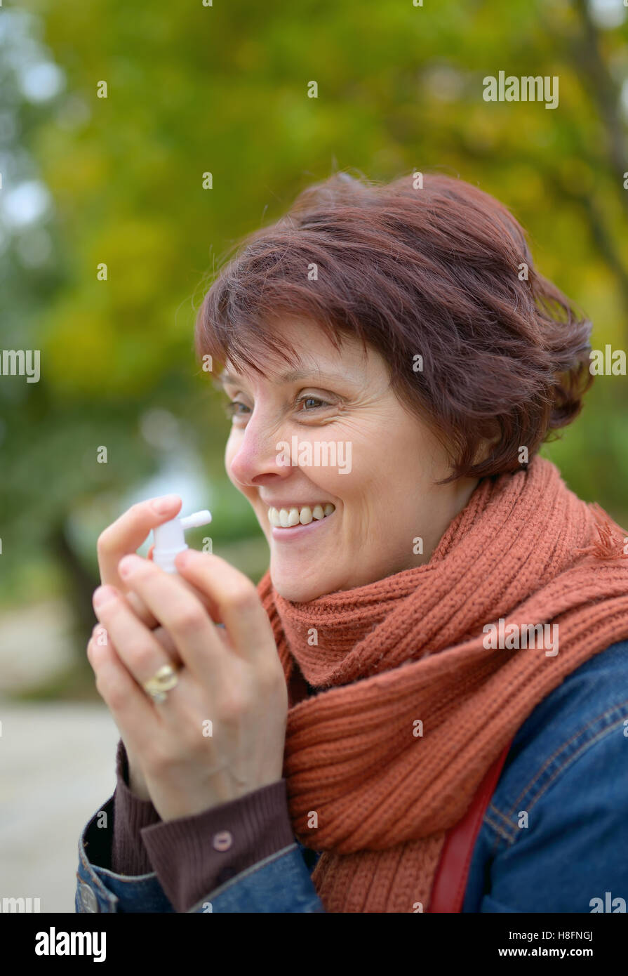 Donna che utilizza spray gola nella stagione fredda Foto Stock