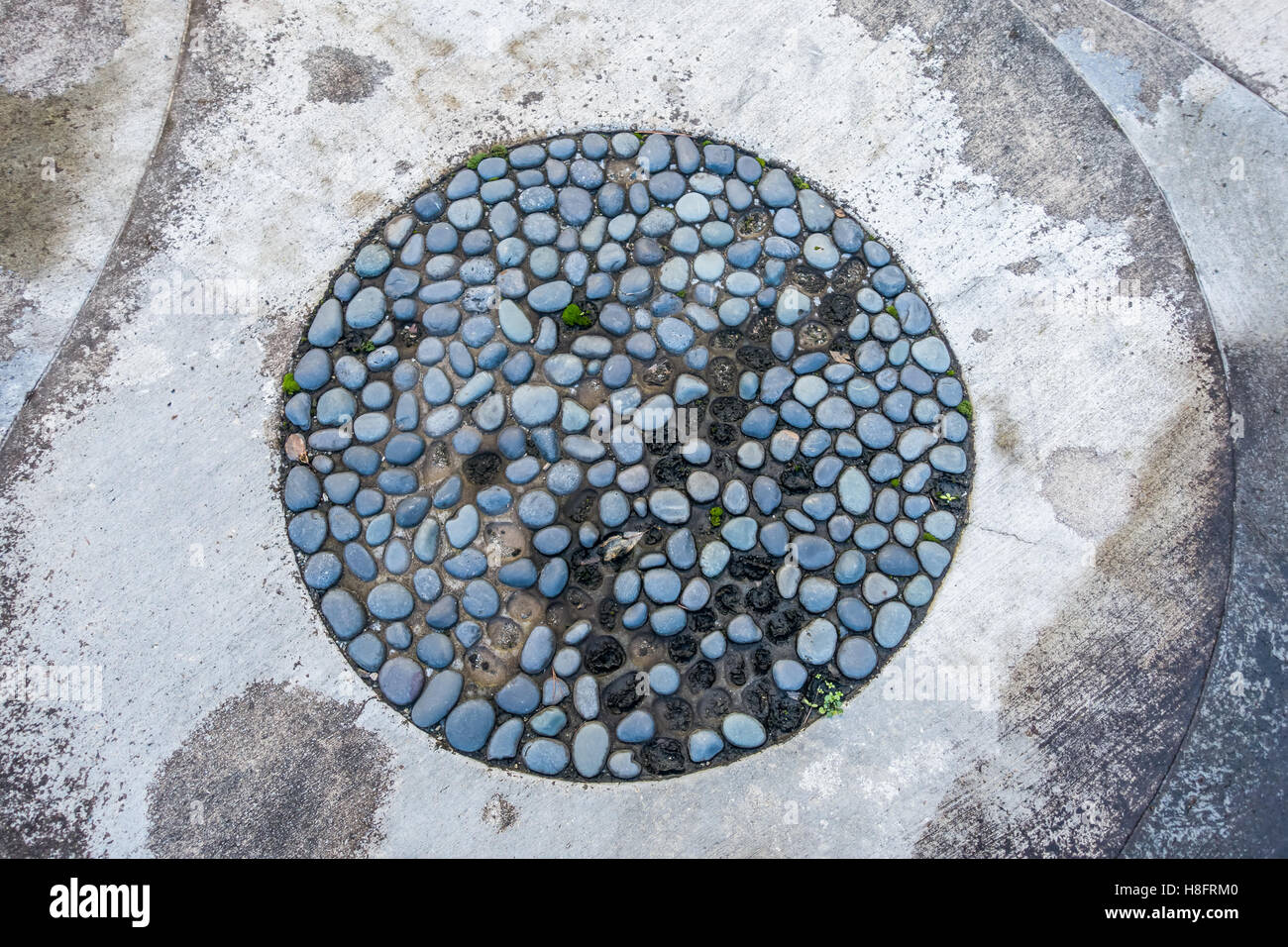 I ciottoli sono incorporati in un cerchio in un patio in Seatac, Washington. Foto Stock