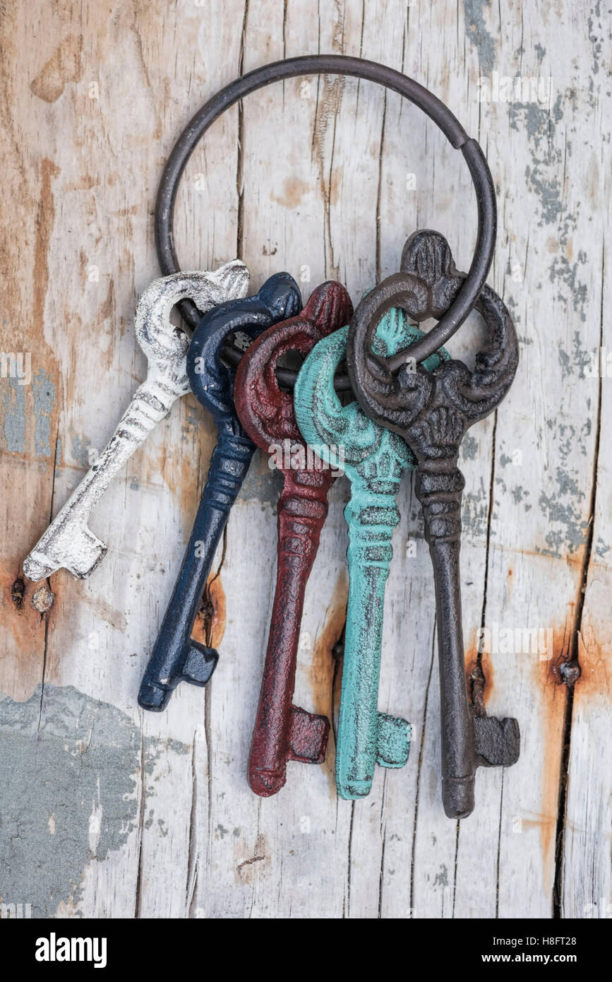 Anello chiave con colorato di vecchie chiavi sul vecchio dalle intemperie  tagliere in legno Foto stock - Alamy