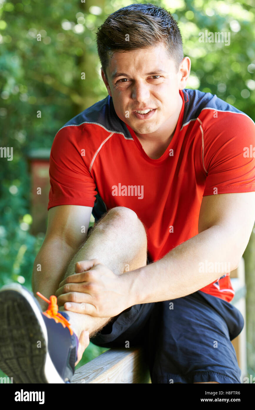 Uomo con sport pregiudizio subito pur esercitando all'aperto Foto Stock