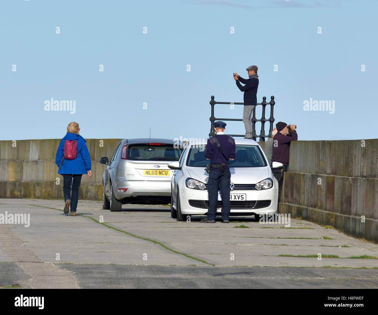 Un vigile tenendo i dettagli di un'auto parcheggiata nel porto di Scarborough North Yorkshire England Regno Unito Foto Stock