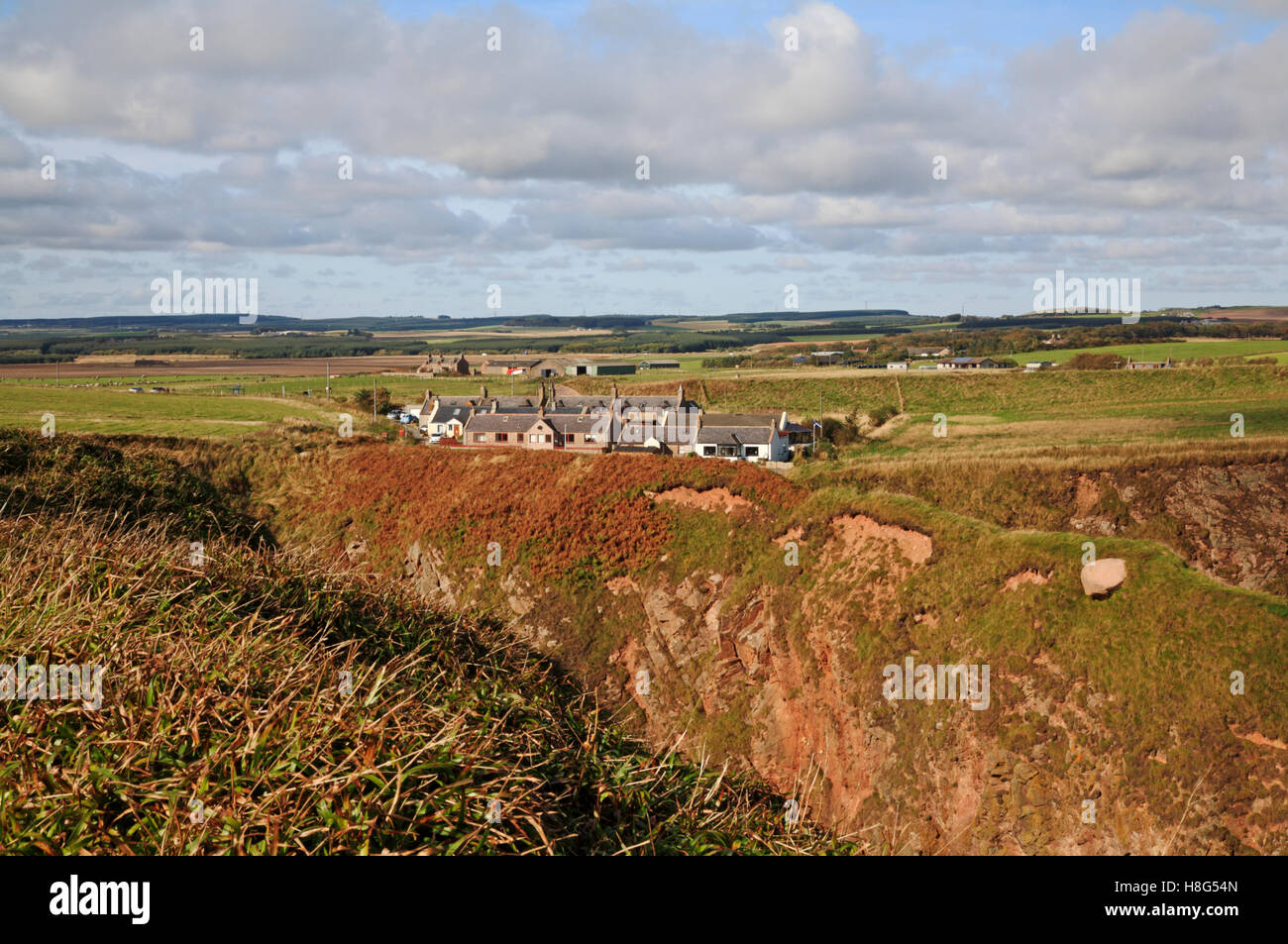 Una vista di cottage sulla rupe a Bullers di Buchan, Aberdeenshire, Scotland, Regno Unito, Europa. Foto Stock