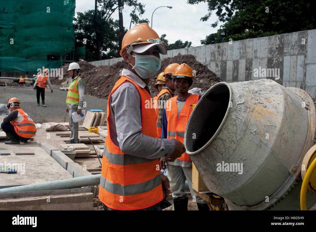 Lavoratori edili sono usando un mescolatore di cemento in un cantiere edile a Phnom Penh in Cambogia. Foto Stock